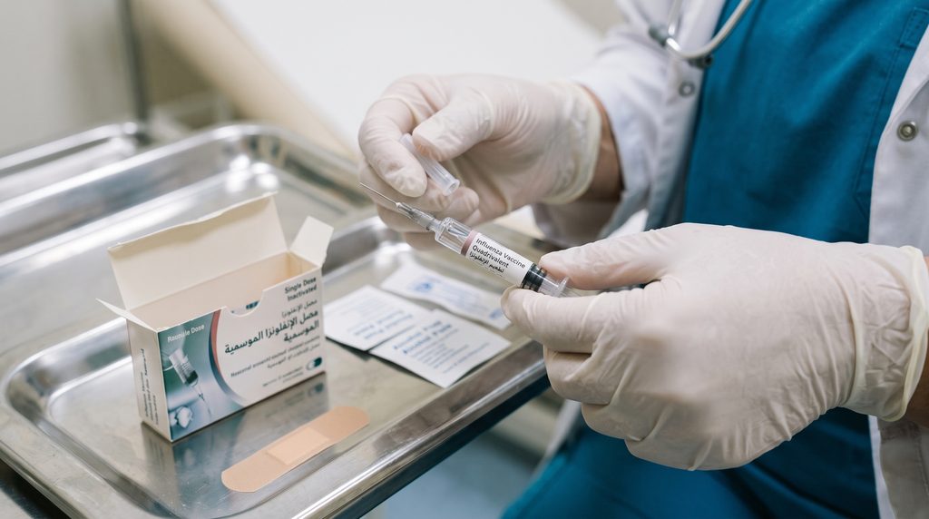 Healthcare professional administering a seasonal flu shot vaccine to an adult patient in a bright, modern medical room at Lorena Oberg Clinic in Hurghada

 طبيب يعطي تطعيم الإنفلونزا الموسمية لمريض في عيادة لورينا أوبيرج بالغردقة